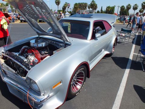 2003 Ford Crown Victoria - silver custom coupe is shown front three-quarter with its hood up over a chromed V8, sporting wide flares and red-lettered tires.