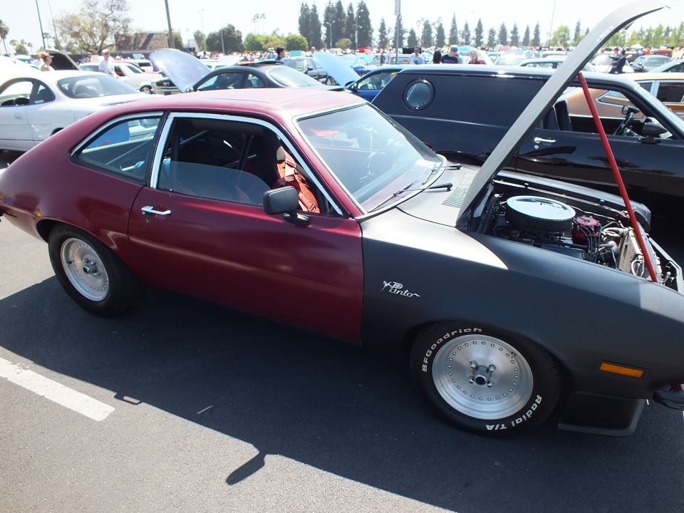 Maroon and gray two-tone Pinto hatchback profile, hood up, white slotted wheels