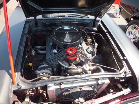2003 Ford Crown Victoria - open engine bay shows a V8 with a black air cleaner, red distributor cap and headers, with a chrome wheel visible at right.
