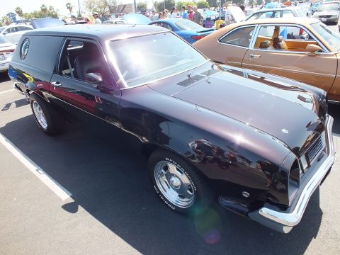 2003 Ford Crown Victoria - glossy dark maroon panel-style wagon is shown front three-quarter with a chrome bumper and chrome mag wheels at an outdoor show.