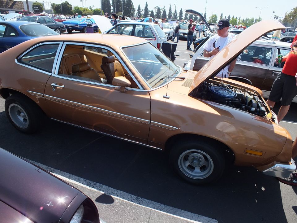 Copper-brown Ford Pinto hatchback profile, hood up, tan interior, mag wheels