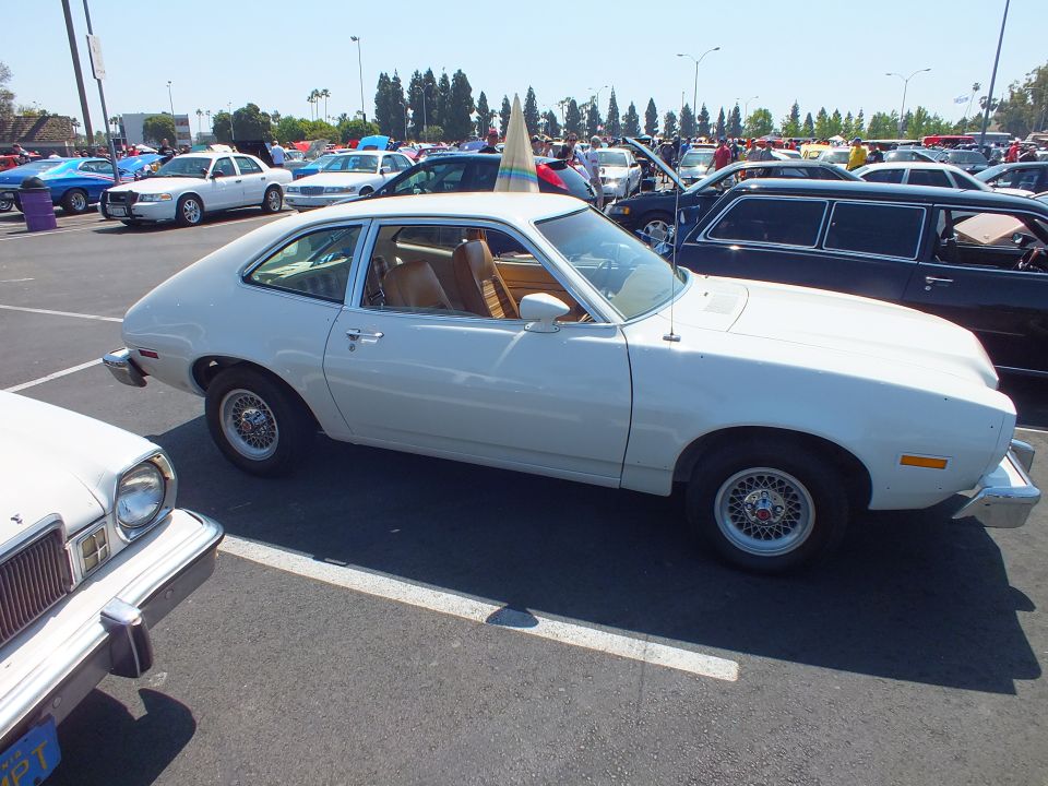 White Ford Pinto hatchback profile with tan interior and wire-style wheels