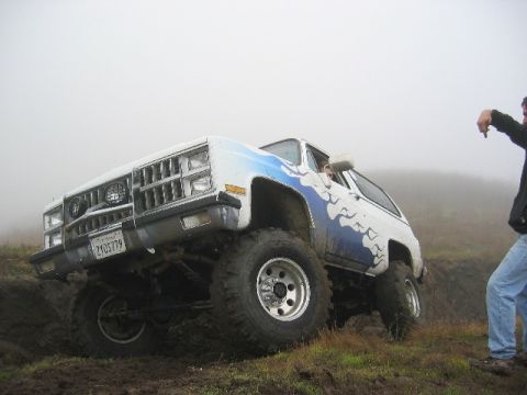 1989 Ford Bronco - This modified SUV is navigating a challenging off-road course with a person observing the action.
