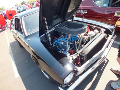 2003 Ford Crown Victoria - engine bay of a small black car shows a rectangular black air box, blue spark plug wires and polished components under the hood.