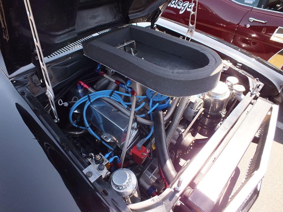 Close-up of engine with oval foam air box, blue wires and braided fittings