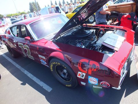 2003 Ford Crown Victoria - maroon vintage fastback race car marked 72 with Goodyear tires and sponsor decals sits with its hood up at a show.