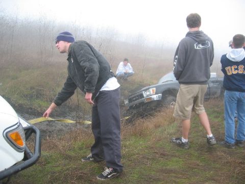 1989 Ford Bronco - A group of people attempt to free a truck stuck in the mud on a foggy day.