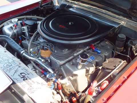 2003 Ford Crown Victoria - detailed vintage V8 engine bay shows a black round air cleaner, blue and red braided line fittings and a signed placard.