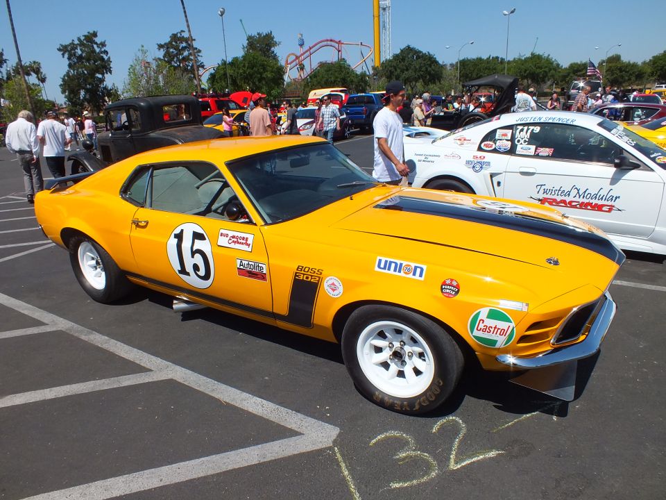 Yellow Mustang Boss 302 race car #15 front quarter view with sponsor decals at show