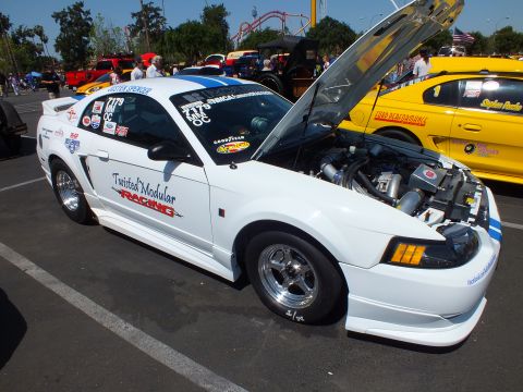 White Ford Mustang drag car Twisted Modular Racing with open hood and supercharger