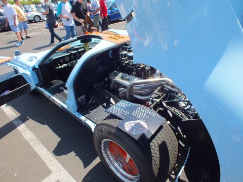 Open rear engine bay of light blue race car with headers