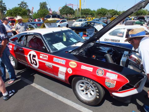 Red and white fastback race car numbered 15 with sponsor decals