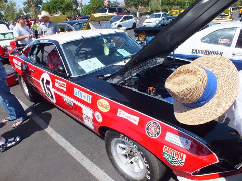 Red and white fastback racer numbered 16 with straw hat on fender