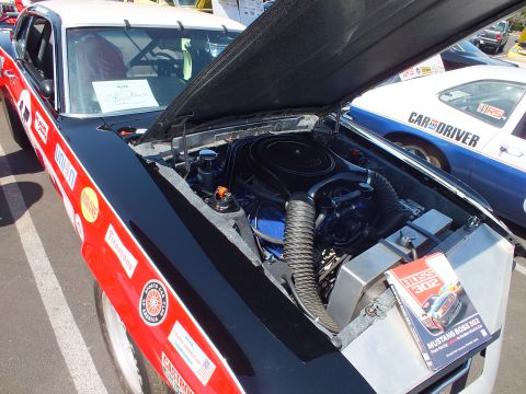 Engine bay of race car with Mustang Boss 302 book on fender