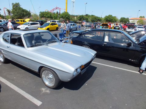 Silver and black fastback coupes parked side by side at an outdoor car show