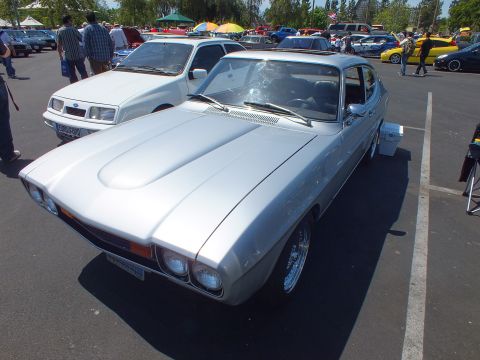 Silver fastback coupe parked at an outdoor classic car show