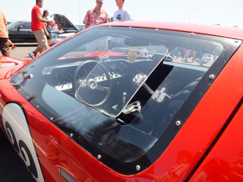 Cockpit of red number race car seen through windscreen with gauges