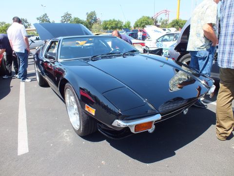 Black wedge mid-engine sports car front three-quarter at outdoor car show