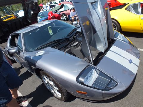 Silver Ford GT with white stripes, clamshell door open, yellow car behind