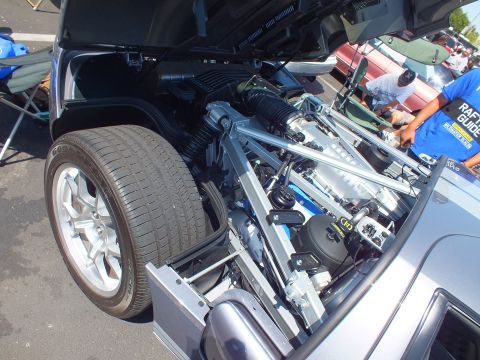 Open front trunk of silver Ford GT exposing front suspension and brake