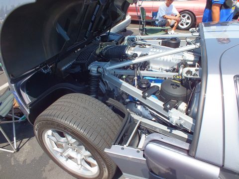 Silver Ford GT engine bay with supercharged V8 and chrome brace bar