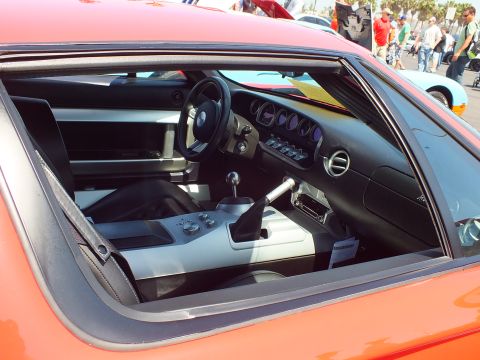 Interior of an orange sports car seen through the side window