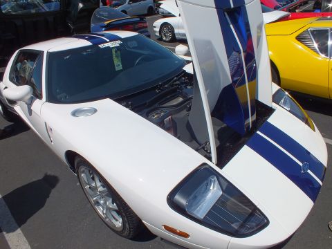 White Ford GT with blue stripes and raised door at a car show