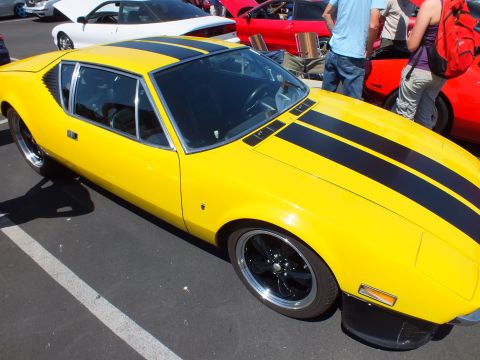 Yellow wedge sports coupe with black stripes and black wheels