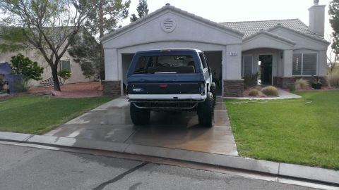 1994 Ford Bronco - A blue Ford Bronco is parked in a driveway in front of a house and garage.