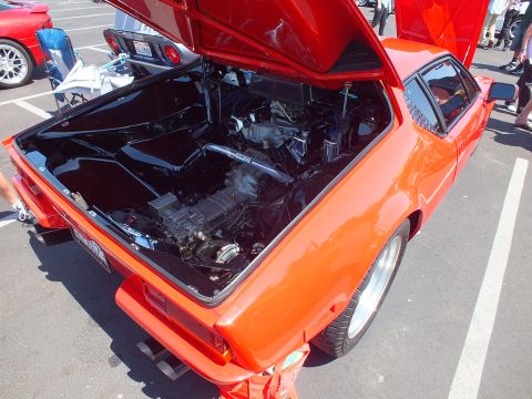 Open rear engine bay of an orange-red wedge sports car
