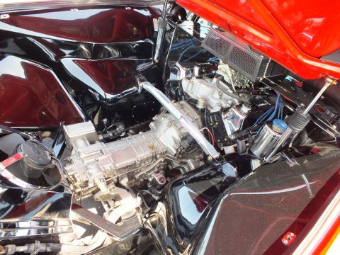 Close-up of a polished mid-mounted engine in a red sports car bay