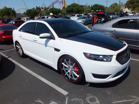 White Ford Taurus SHO sedan with black hood stripe and chrome wheels