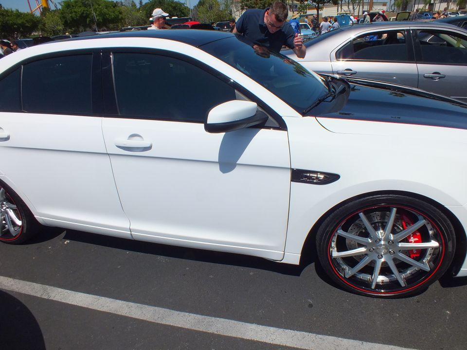 Side profile of a white sedan with chrome multi-spoke wheels and red calipers