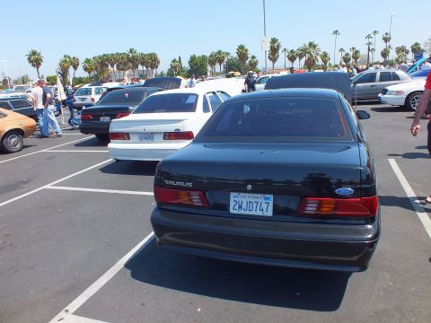 Rear of a black Ford Taurus sedan with California plate 2WJD747