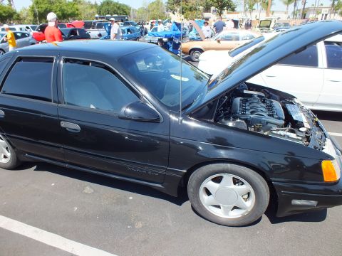 Black Ford Taurus SHO sedan with hood open showing V6 engine