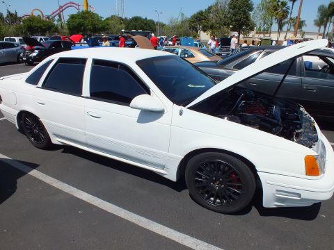 White Ford Taurus SHO sedan with hood open and black mesh wheels