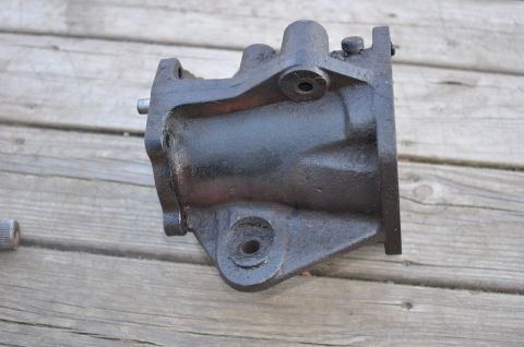 1974 Ford Bronco - A close-up view of a black metal steering gear box rests on a weathered wooden surface.