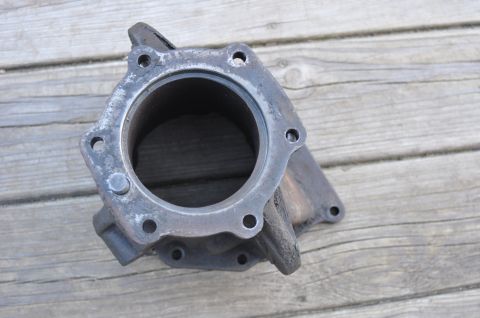 1974 Ford Bronco - A metal engine component rests on weathered wooden planks.
