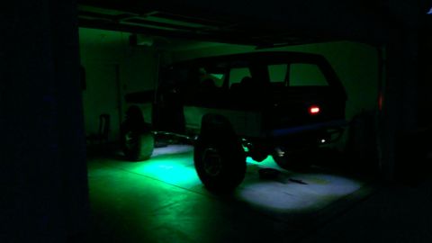 1994 Ford Bronco - This SUV is parked in a garage with bright green lights illuminating the floor underneath it.