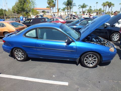 Blue Ford Escort ZX2 coupe with hood up on silver wheels