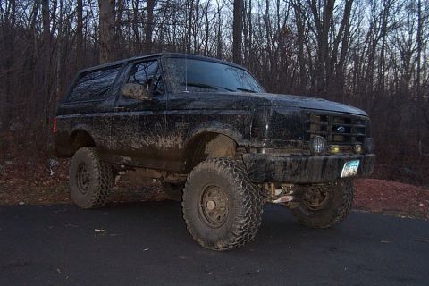 1996 Ford Bronco - This lifted 1996 Ford Bronco is covered in mud, suggesting it has seen some off-road action.