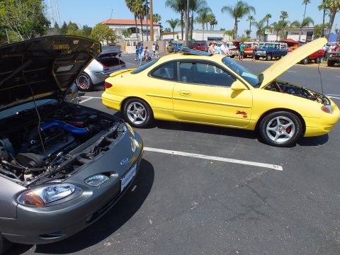 Yellow Ford Escort ZX2 coupe parked at outdoor car show