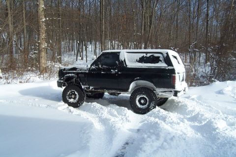 1996 Ford Bronco - Black 1996 Ford Bronco navigating a snowy, wooded area.