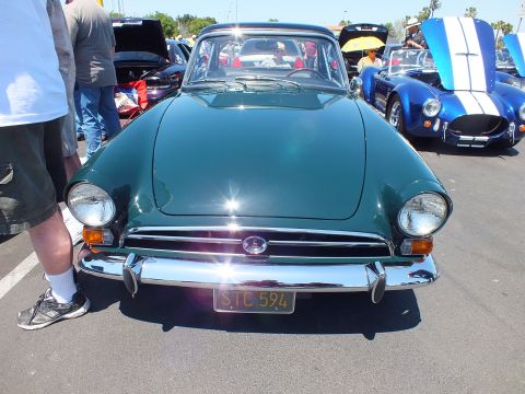 Front view of a dark green sports coupe with yellow plate reading STC 594 at a car show