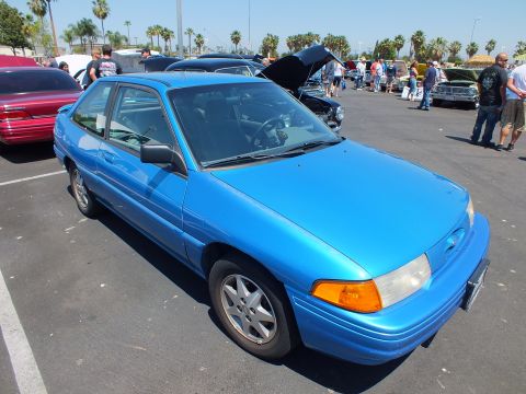 Blue Ford Escort two-door hatchback parked at a car show