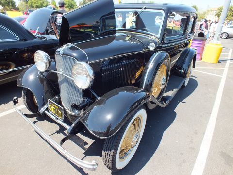 Black 1932 Ford sedan front three-quarter with hood open at a show