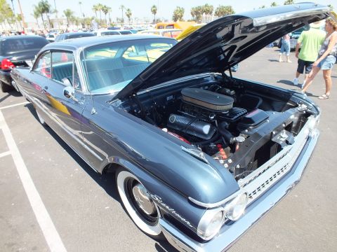 Dark blue Ford Starliner hardtop with hood open at a car show