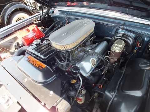 Classic V8 engine with finned valve covers and a caution decal