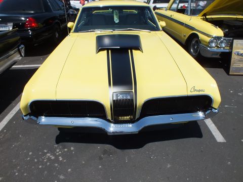 Front view of a yellow Mercury Cougar with black hood stripes