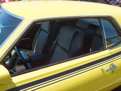 Interior of a yellow car showing black-and-white houndstooth bucket seats